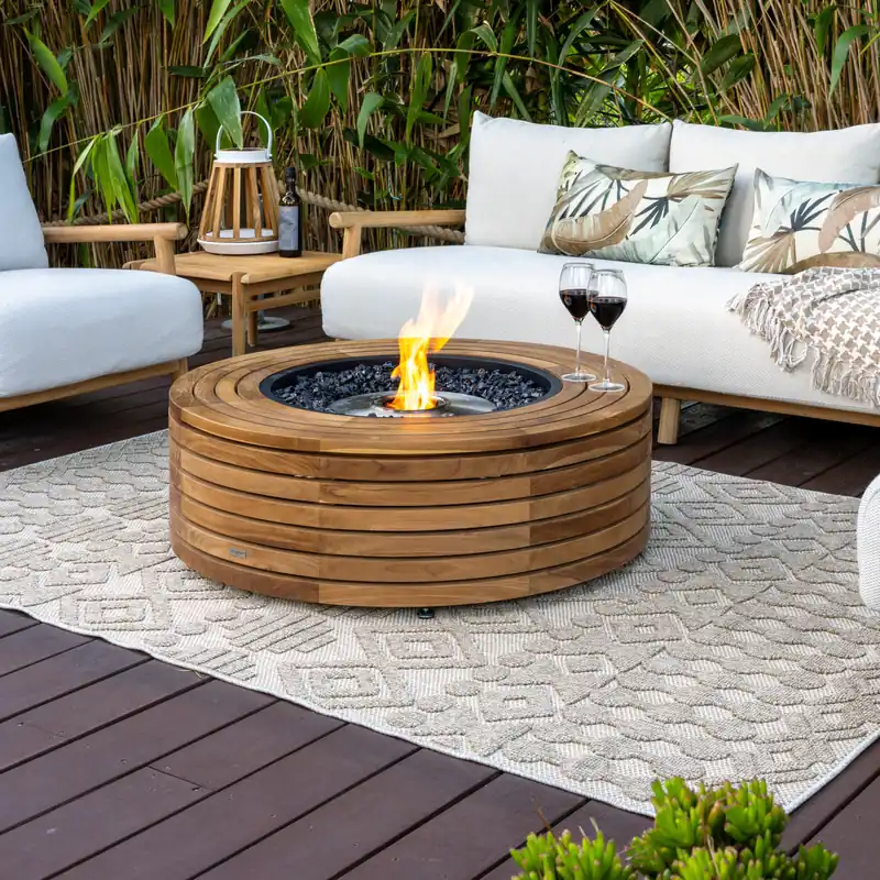 EcoSmart Ark 40 fire table in teak burning between white outdoor sofas on a pale rug